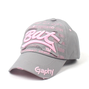 Détail d'une casquette grise avec broderie rose en relief et finitions effet usé vintage