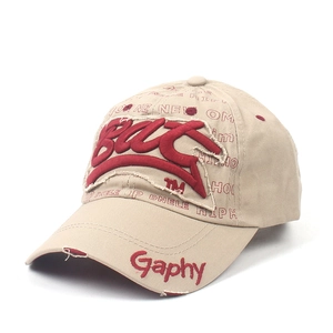 Détail de la broderie rouge Bax et du tissu en sergé kaki vieilli de la casquette
