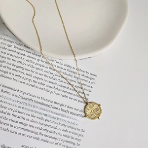 Macro view of a 925 silver vintage golden sunburst pendant necklace on a book