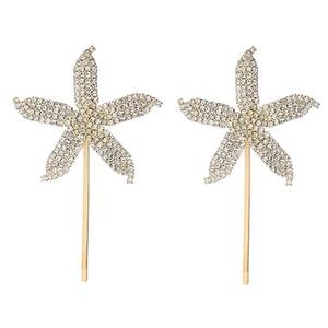 Detailed view of two gold starfish hair clips featuring sparkling clear crystal rhinestones