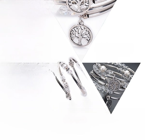 Macro detail of white crystal and shell pearl multi-layer bracelet with tree of life charm