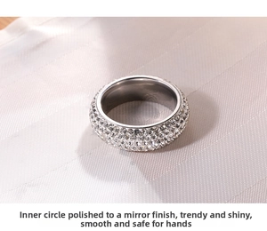 Detailed macro view of 5-row crystal paved stainless steel ring with polished inner surface