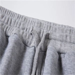 Detail of the elastic waistband and gray drawstring on heavy knit sweatpants for sports