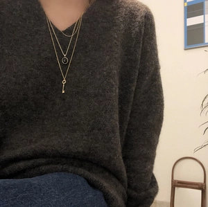 Three-layer 925 sterling silver necklace featuring key and black round pendants in gold finish