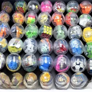 Macro shot of 47x55mm clear plastic capsule toy shells with assorted mini puzzles inside
