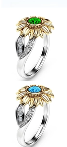 Detailed view of sunflower rings with 18k gold petals and blue-green gemstones