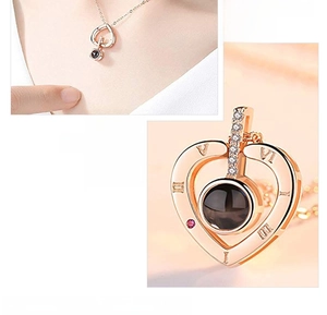 Close-up of rose gold heart necklace with Roman numerals and centered projection stone