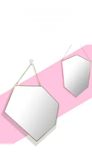 Detalle del espejo hexagonal nórdico de latón dorado con marco fino y cadena colgante