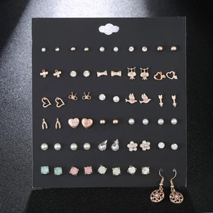 Detailed set of 35 pairs golden stud earrings with pearls and crystals on black card