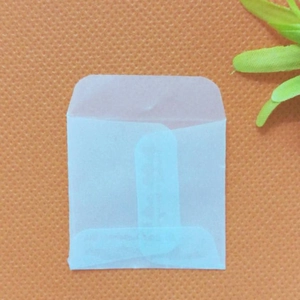 Translucent vellum paper envelopes for small jewelry and gift storage on orange surface