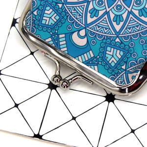 Macro view of blue mandala pattern fabric and silver metal kiss-lock clasp on the coin purse