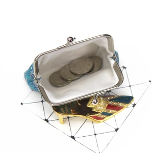 Detail of blue geometric print coin purse with vintage metal clasp and internal coins