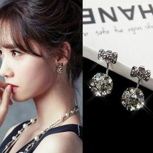 Detail of silver bow earrings with large sparkling crystal and model wearing shot