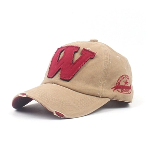 Detailed view of vintage khaki baseball cap with frayed red W patch and embroidery