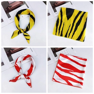 Detail view of zebra print silk scarves in yellow-black and red-white color schemes