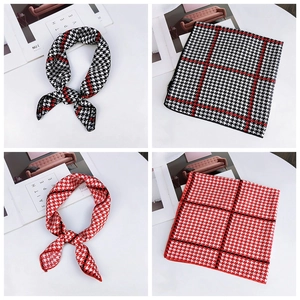 Detail of elegant houndstooth silk square scarf in red and black checkered patterns