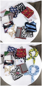 Detail of assorted printed silk scarves with polka dot and leopard patterns on a white tray