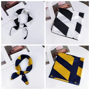 Detail view of geometric silk scarves with navy and yellow patterns on white background