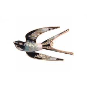 Close-up of elegant swallow brooch with blue enamel wings and sparkling crystals