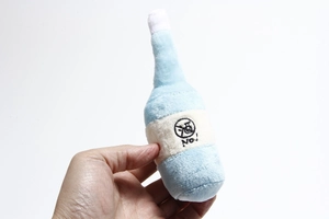 Detail of blue plush bottle dog toy with 'No!' embroidery and squeaker design
