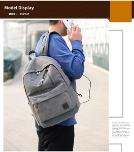 Dettaglio zaino in tela grigia con porta di ricarica USB esterna e logo in pelle