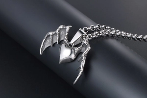 Macro shot of vintage silver dragon wing heart pendant on a premium metal chain