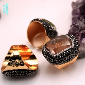 Detalle macro de anillo de oro ámbar con piedra rectangular y textura martillada