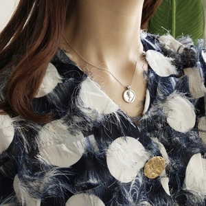 Detail of vintage 925 sterling silver coin necklace featuring rose relief pendant