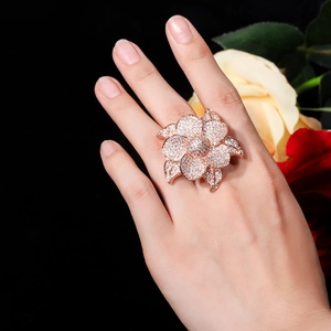 Close-up of a sparkling rose gold flower ring with micro-paved AAA zircons on a hand