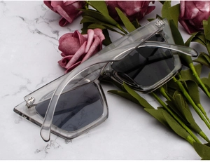 Makro-Detail der transparent grauen eckigen Sonnenbrille mit silbernen Metallscharnieren
