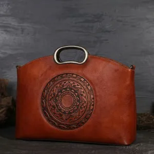 Detailansicht der braunen Vintage-Lederhandtasche mit Metallgriff und geprägtem Muster.