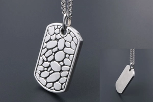 Detail view of silver titanium steel dog tag pendant with pebble texture and smooth back