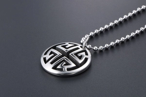 Detailed close-up of a silver hollow circular pendant necklace with an elegant cutout design