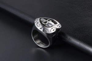 Détail macro d'un relief de crâne gothique sur une bague bouclier coeur en acier argent