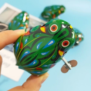 Retro green metal wind-up frog toy with colorful patterns and mechanical spring knob