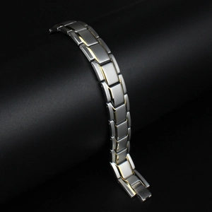 Detail of silver and gold toned magnetic link bracelet on a professional dark background