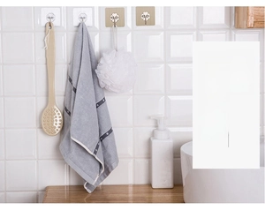 Adhesive wall hooks in transparent and gold style holding bath towels and shower brushes