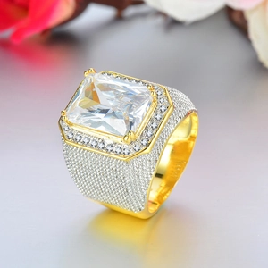 Macro shot of gold plated hip hop men's ring with large rectangular zircon and iced out stones