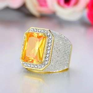 Macro side view of a gold-toned hip hop ring with a yellow radiant-cut cubic zirconia