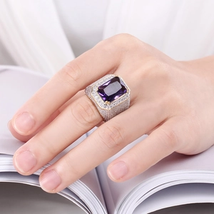 Detail of square purple zircon ring in two-tone metal finish worn on hand