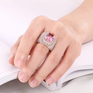 Macro shot of silver ring with large pink step-cut zircon and pavé diamond setting