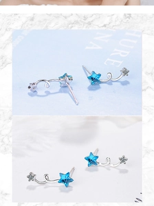 Detailed view of star-shaped stud earrings with blue crystals and silver metal setting