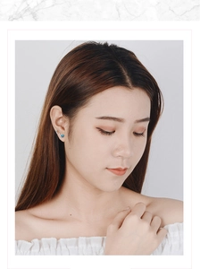 Close-up of a blue star crystal earring with wavy silver setting on female model ear