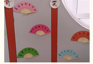 Gros plan d'éventails en papier DIY colorés avec tiges en bambou pour déco murale