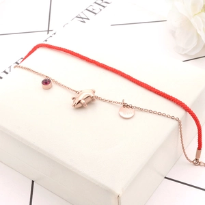 Rose gold pig pendant and Fu character medallion on a red rope and chain bracelet
