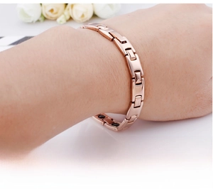 Detail of rose gold stainless steel magnetic health bracelet with polished finish