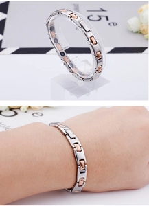 Detail showing two-tone magnetic therapy bracelet in silver and rose gold on wrist