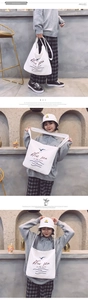 Detailed view of white canvas shoulder bag featuring blue sea summer seagull print graphics
