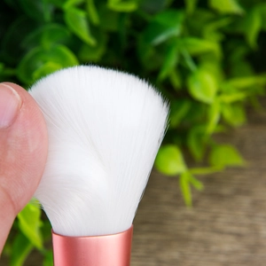 Soft synthetic powder brush head with rose gold ferrule and white bristles for smooth makeup