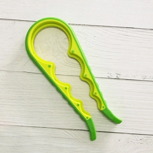 Detail of multi-size non-slip jar opener showing green and yellow handle on white wood